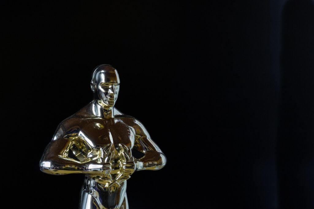 Alt = "Stylized Oscar statuette with a blurred face against a dark background, accompanied by the caption ‘Oscars 2026 Recap: Horror History, Big Wins, and the Night Hollywood Shifted