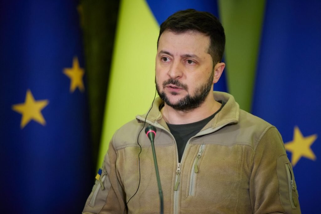 Alt = "Volodymyr Zelenskyy speaks at a podium in front of Ukrainian and EU flags during an official address; related to ongoing international support for Ukraine, including high‑profile advocacy such as Sean Penn’s Ukraine-focused appearances at the Oscars. Sean Penn Ukraine Oscars"
