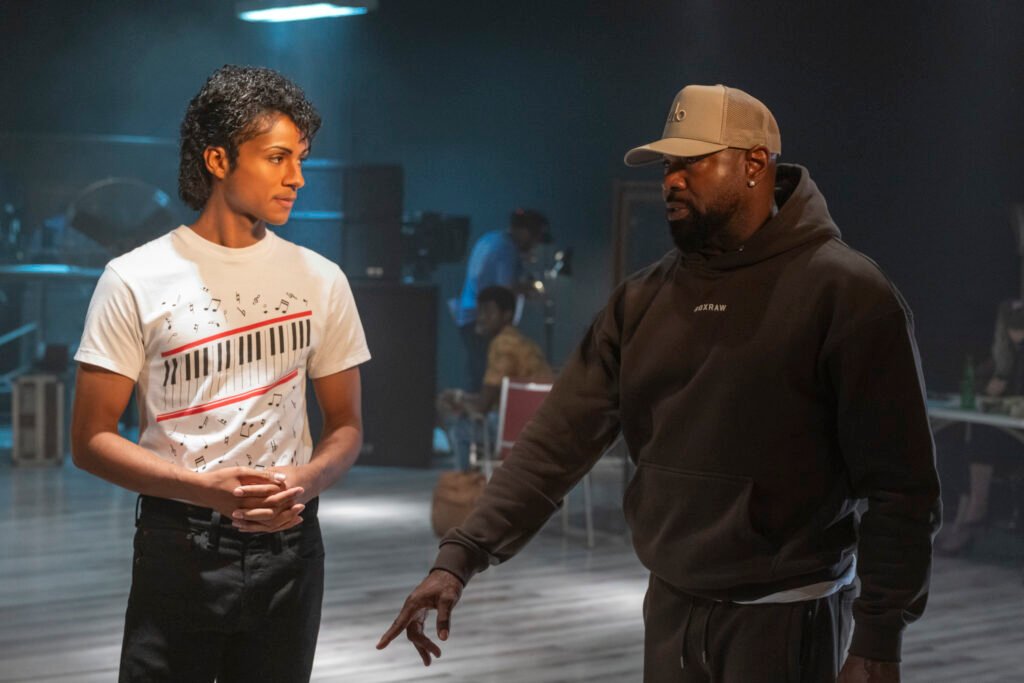 Alt = Jaafar Jackson as Michael Jackson and Director Antoine Fuqua in Michael. Photo Credit: Glen Wilson/Lionsgate and Universal Pictures Michael biopic movie review