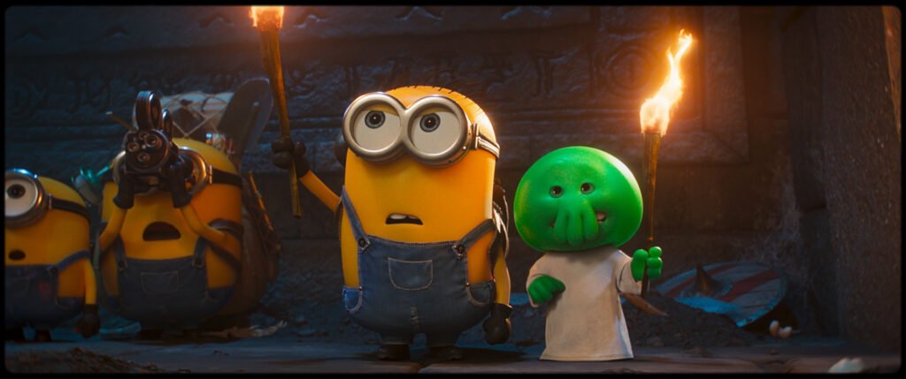 Alt = A scene from Minions & Monsters featuring L to R: James, Ed, Henry and Goomi (Voiced By Trey Parker) in Illumination’s Minions & Monsters, directed by Pierre Coffin. © Universal Studios. All Rights Reserved.
Minions & Monsters Review