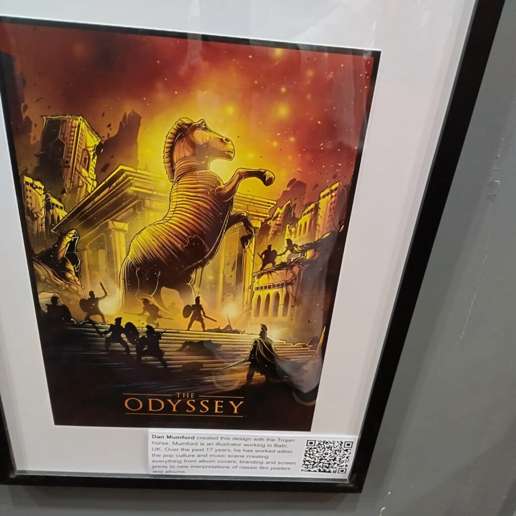 Alt = Poster (The Trojan Horse): A dramatic cinematic piece focusing on the massive wooden Trojan Horse standing under a golden sky during the sack of Troy.